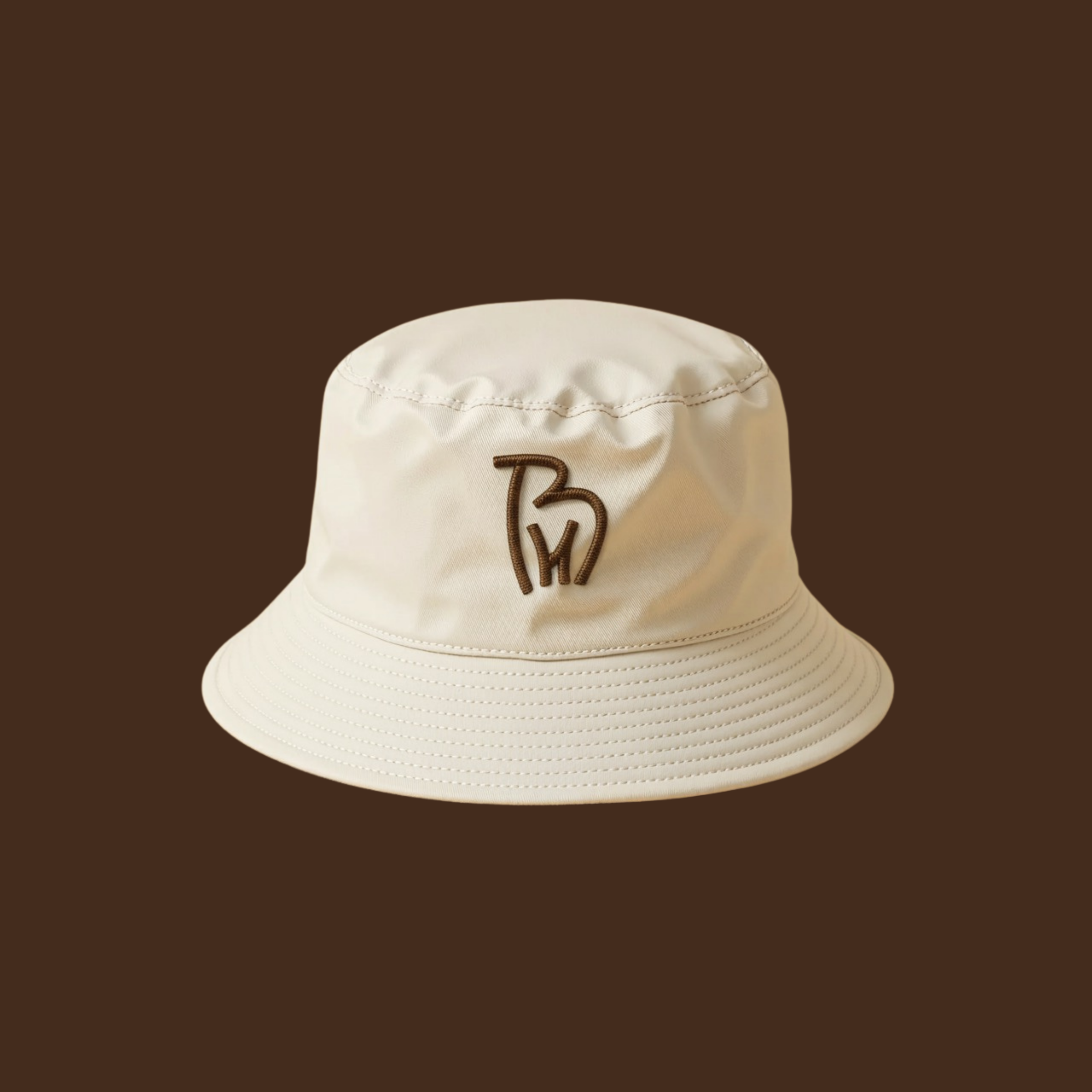 BH Cattle Farm logo embroidered on a cream bucket hat mockup using cork brown monogram for ranch apparel branding